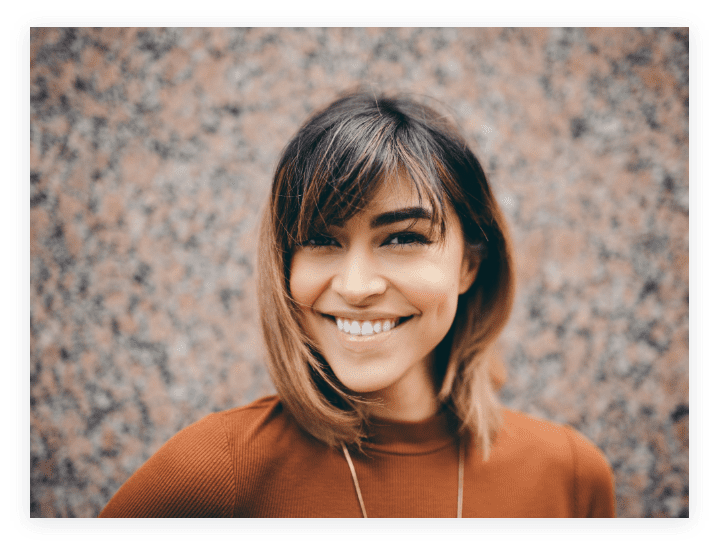 Image of young woman with medium-length hair and a bright smile