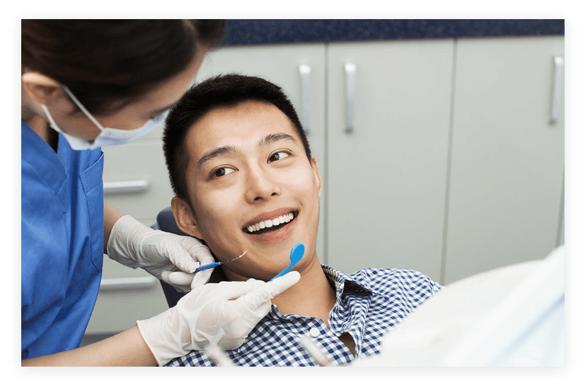 Photo of young man with bright smile sitting in a dental chair