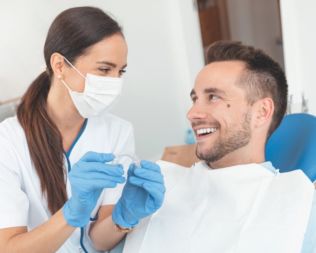 Man sitting in orthodontist chair discussing treatment