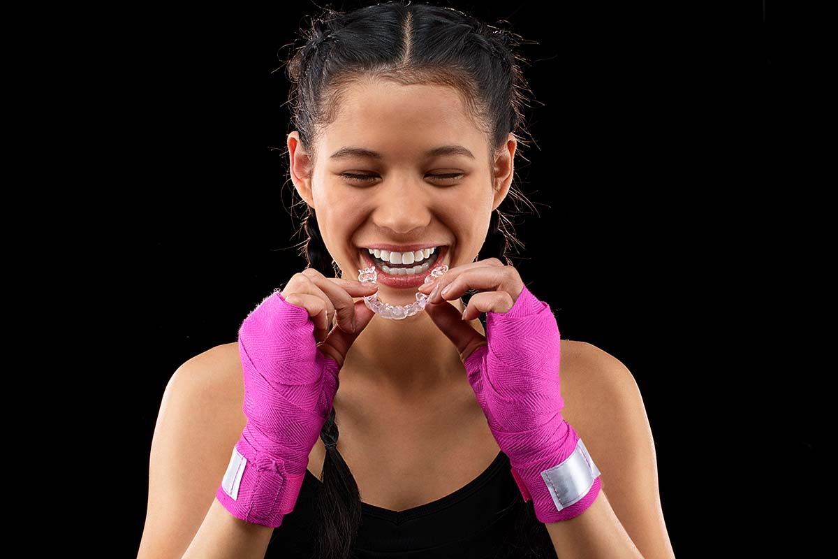Teen-girl-kickboxer-inserts-Invisalign-clear-aligner-1024x683-1