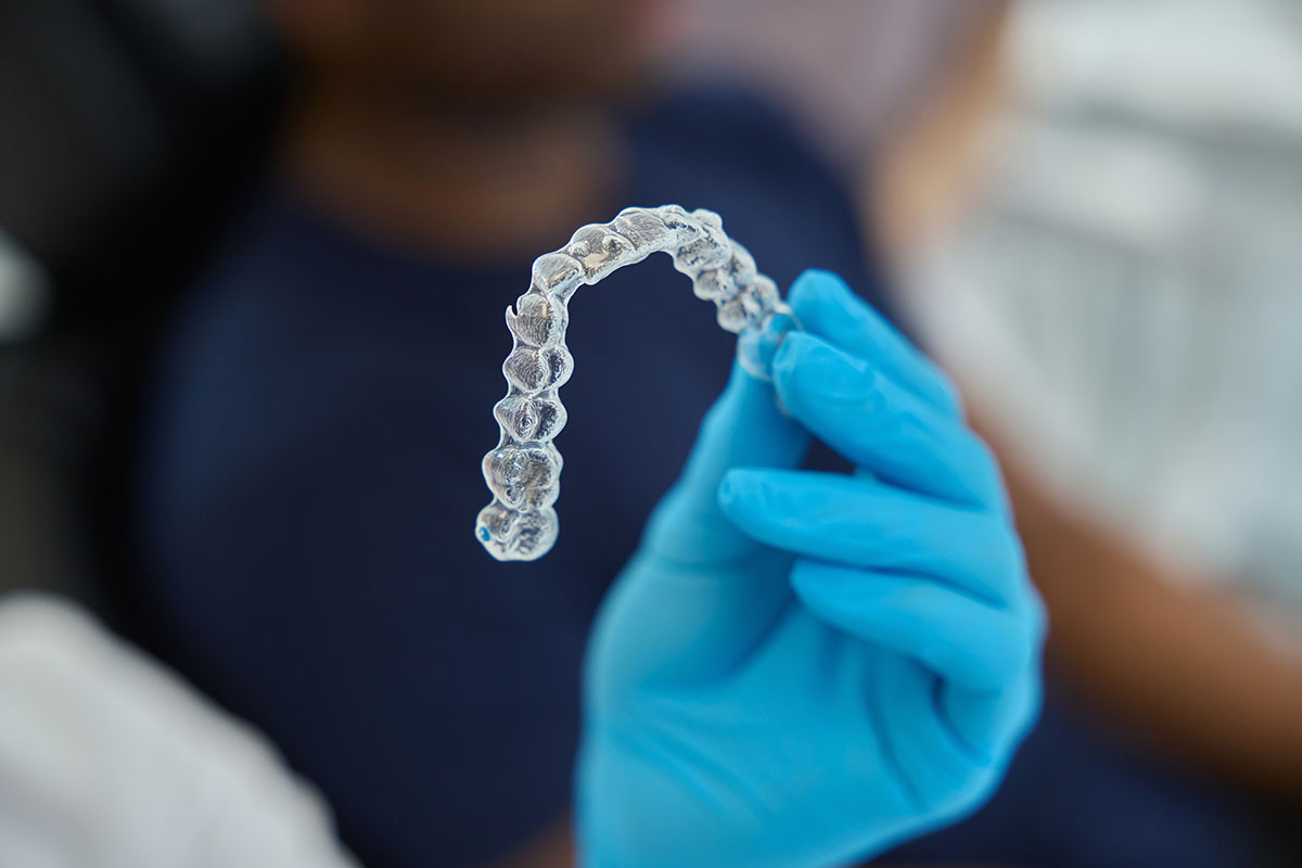 orthodontic professional holding a clear aligner